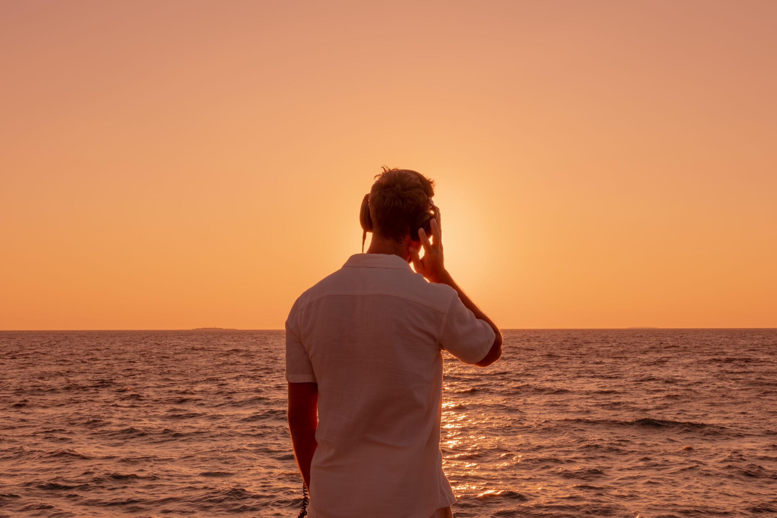 DJ Karl legt beim Sundowner auf den Malediven auf – Meer und Sonnenuntergang im Hintergrund